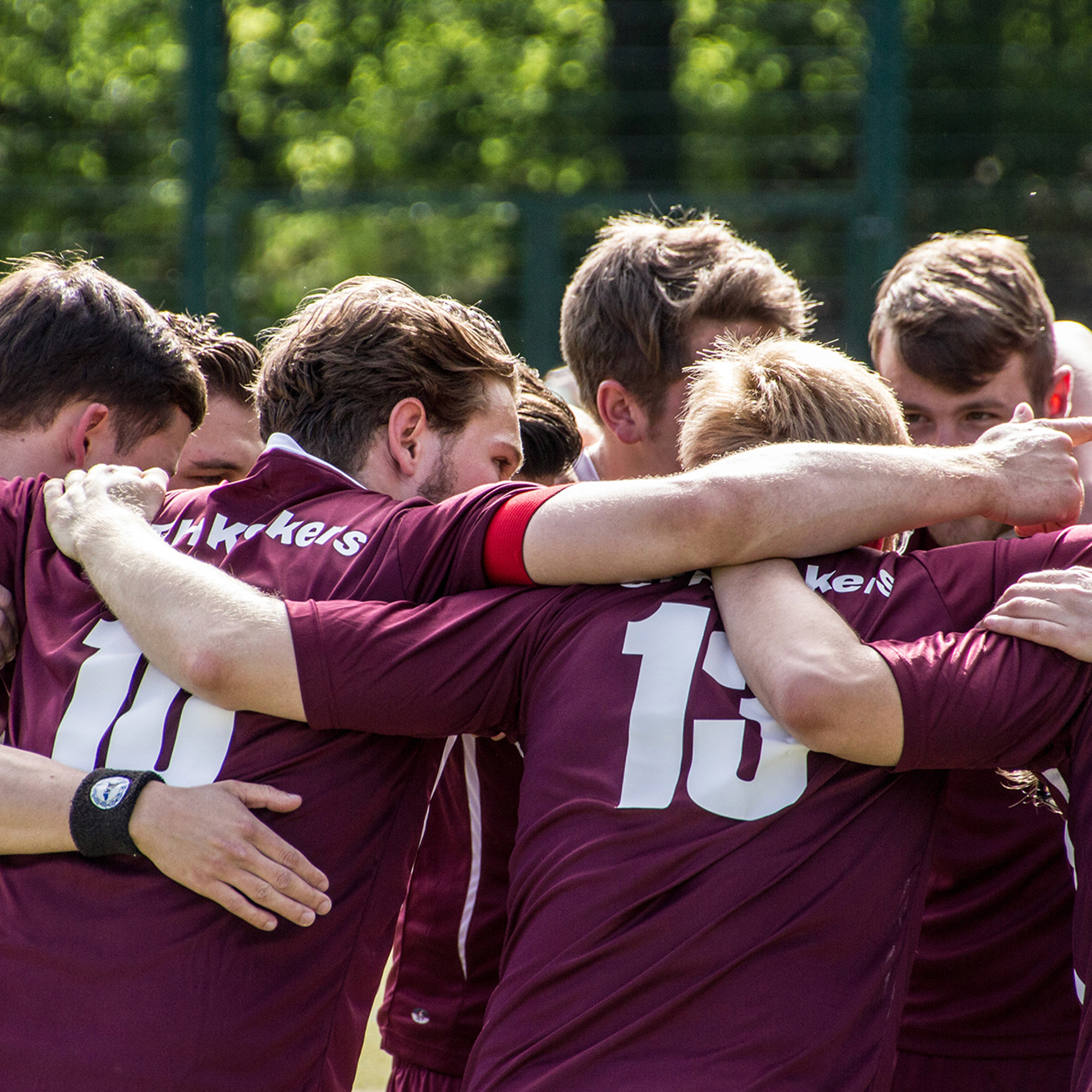 Sports team huddling in maroon jerseys